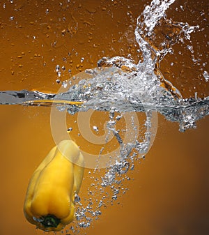 Yellow pepper falling into water