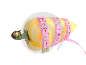 Yellow pepper with pink tape measure against white background