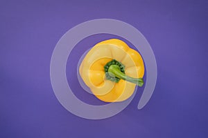 A yellow pepper on a purple background. Complimentary color style.