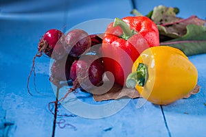 yellow pepper, red pepper and beetroots shooted on blue wooden t photo