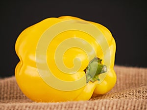 A yellow pepper with a rustic background