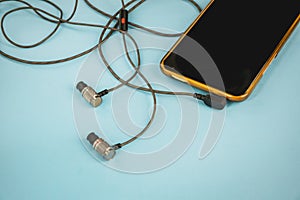 Yellow phone with headphones on a blue background.