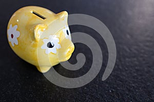 yellow piggy bank on a black stone  background. Saving money. Finance and savings economy