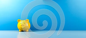 Yellow piggy bank in the corner of a room, blue wall, For art texture, presentation design or web design and web background.