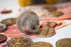 yellow piggy bank on euro coins and bank notes on wh