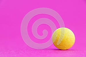 Yellow pill isolated on pink background with clipping path. Medicine and pharmacy concept