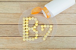 Yellow pills forming shape to B7 alphabet on wood background