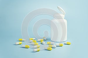 Yellow pills, plastic white bottle. Blue background with copy space for text. the concept of health medicine and pharmacy.