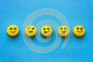 Yellow pills with smiles on a blue background. The concept of tr