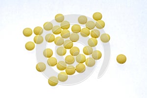 Yellow pills on a white background