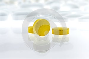 Yellow pills on white background