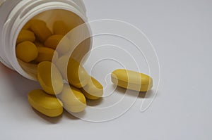 Yellow pills on a white background. Homeopathy, tranquilizers, antibiotics