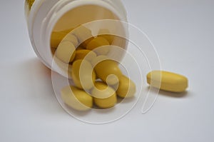 Yellow pills on a white background. Homeopathy, tranquilizers, antibiotics