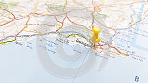 A yellow pin stuck in Cartagena on a map of Spain photo