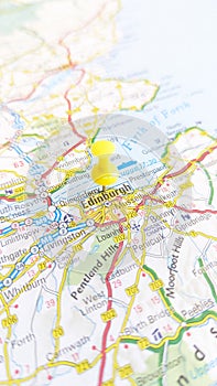 A yellow pin stuck in Edinburgh on a map of Scotland portrait