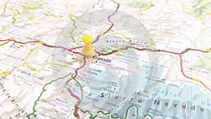 A yellow pin stuck in Grenada on a map of Spain photo
