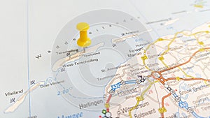 A yellow pin stuck in the island of Terschelling on a map of the Netherlands