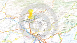 A yellow pin stuck in Lake Iseo on a map of Italy