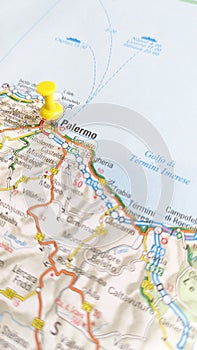 A yellow pin stuck in Palermo Sicily on a map of Italy portrait