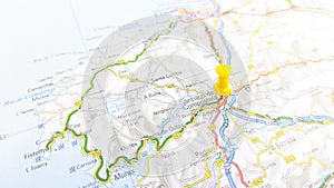 A yellow pin stuck in Santiago de Compostela on a map of Spain