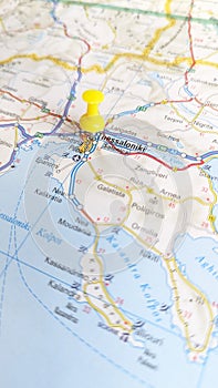 A yellow pin stuck in Thessaloniki on a map of Greece portrait photo