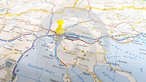A yellow pin stuck in Thessaloniki on a map of Greece photo