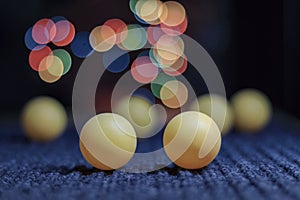 Yellow ping pong ball, with bokeh background, on black background