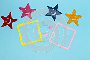 yellow and pink frame as copy space on blue background, colorful stars around