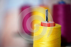 Yellow and pink reels of thread at tailors
