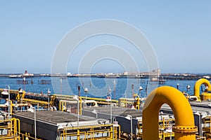 Yellow pipes and connections with background of sea