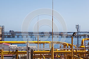 Yellow pipes and connections with background of sea