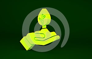 Yellow Plant in hand of environmental protection icon isolated on green background. Seed and seedling. Planting sapling