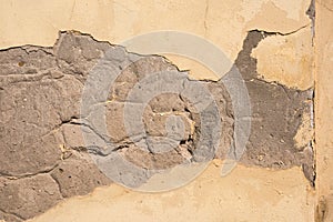 Yellow plaster falls off the wall