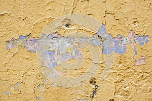 Yellow plastered wall with damages. Empty brickwall with uneven surface