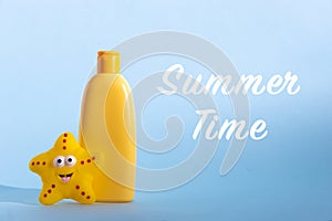 Yellow plastic bottle with baby cosmetic and funny toy. Sunscreen lotion. The concept of children's sun protection