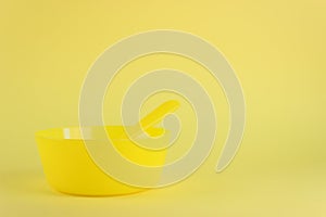 Yellow plastic bowl on yellow background