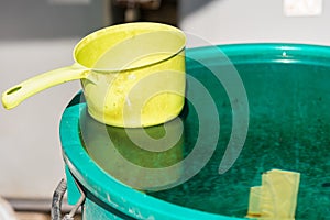 Yellow plastic bucket in the water tank