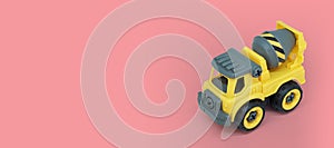 Yellow plastic concrete mixer truck toy isolated on ink background.