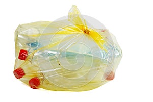 Yellow plastic garbage bag with used PET bottles isolated on white