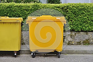 Yellow plastic garbage can in the street