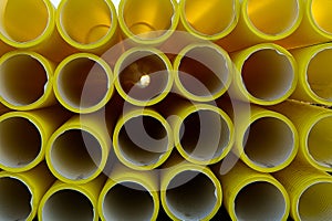 Yellow plastic pipes for laying electricity cables underground. texture or abstract background.