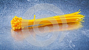 Yellow plastic self-locking cable ties on metallic background co