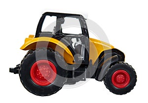 Yellow plastic traktor toy. Farming vehicle, harvest equipment