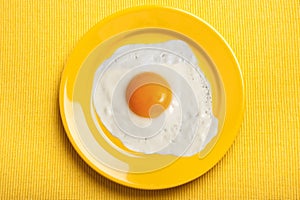 Yellow plate over yellow background with egg omelette