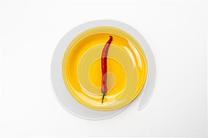 Yellow plate with red Chili pepper, top view