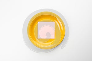 Yellow plate with a sheet of paper