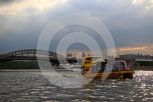 Yellow pleasure boat floats across the Moskva River