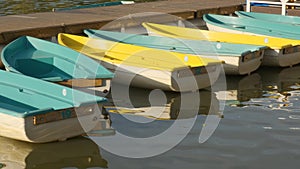 Yellow pleasure boats in the pond. Boat station. Fun boats. Recreation Park. Water recreation. Rowing.