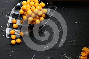 Yellow plums with sunflower on the black background. Ingredients for a jam. Food photography. Yellow sunflower,
