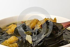 Yellow pollack seaweed soup on white background
